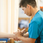 院長が患者さんの足首と足の動きを検査している様子