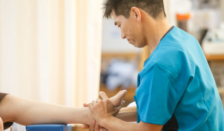 院長が患者さんの足首と足の動きを検査している様子