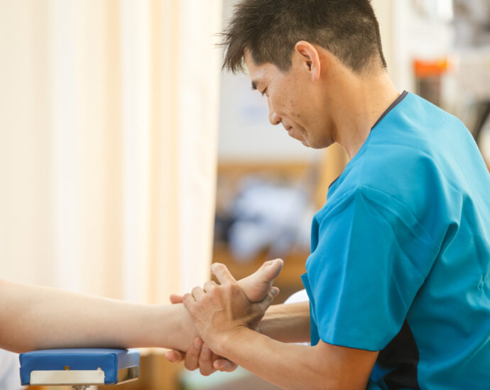 院長が患者さんの足首と足の動きを検査している様子