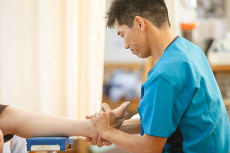 院長が患者さんの足首と足の動きを検査している様子