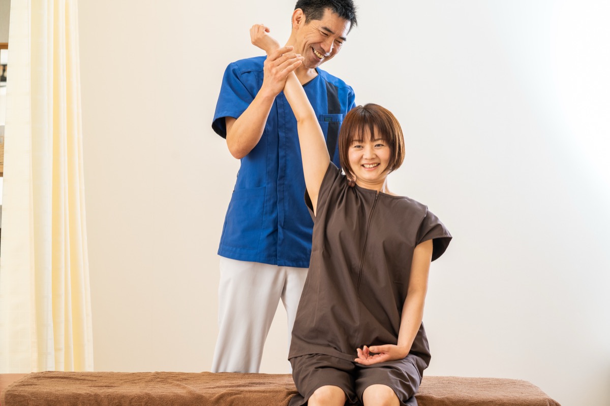 施術後に腕を上げて動きの変化を確認する患者さん