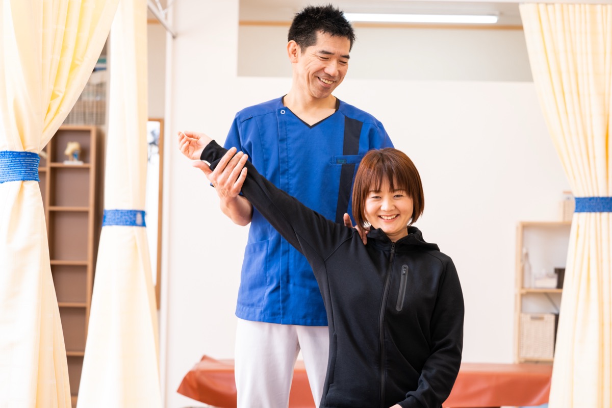 立った姿勢で腕を上げてもらい、肩と肩甲骨の動きや左右差を確認しているところ